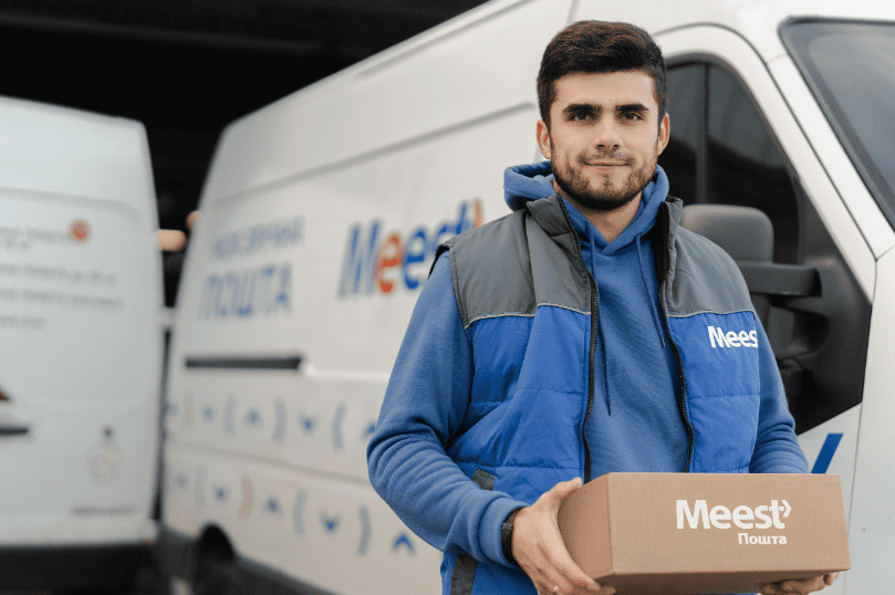 Кур'єр Meest Пошта тримає коробку з посилкою.
