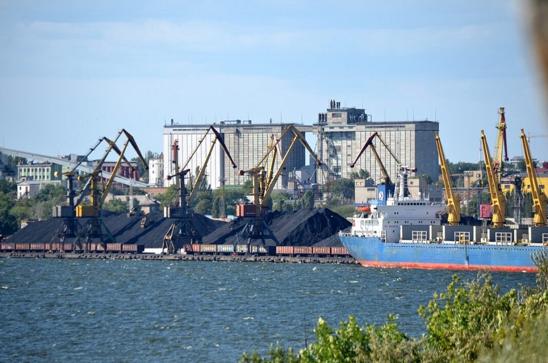 Одеський морський порт із вантажним судном та портовими кранами.