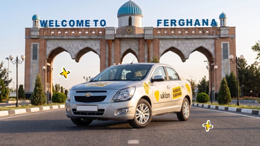 Сріблястий автомобіль Chevrolet з брендуванням сервісу замовлення поїздок Uklon біля арки з написом 